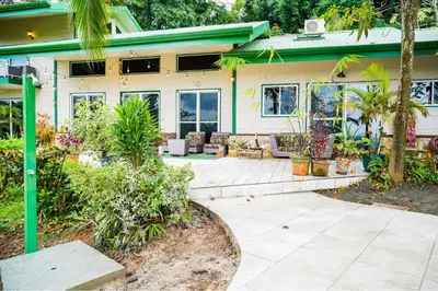 a house with a patio with plants and trees at Jungle Jewel in Quepos