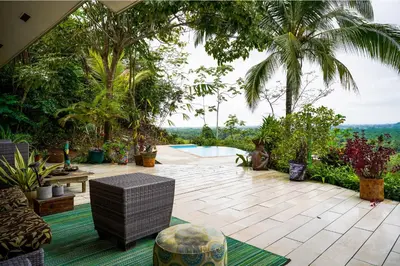 a patio with a pool and a bunch of plants at Jungle Jewel in Quepos