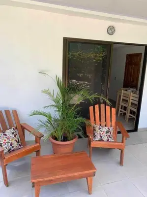 a porch with two chairs and a potted plant at Calma Place in Carrillo
