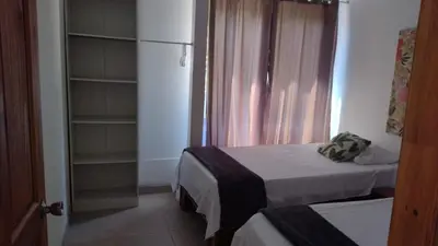 a small room with two beds and a refrigerator at Calma Place in Carrillo