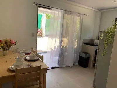 a dining room with a table and a door to a kitchen at Calma Place in Carrillo