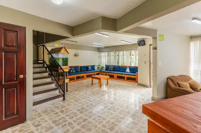 a living room with a couch and a stair case at Las Carmelas, Airport Juan Santamaría, Alajuela, San José in Alajuela City