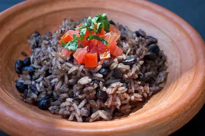 a wooden bowl of rice with beans and vegetables at Las Carmelas, Airport Juan Santamaría, Alajuela, San José in Alajuela City