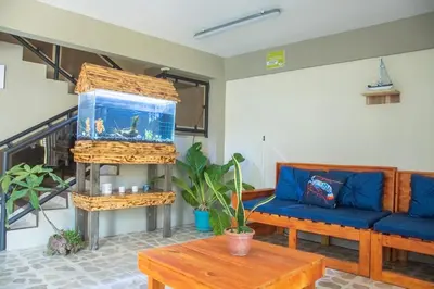 a living room with a blue couch and a fish tank at Las Carmelas, Airport Juan Santamaría, Alajuela, San José in Alajuela City