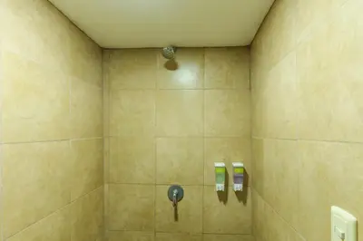 a bathroom with a shower with two soap dispensers at Las Carmelas, Airport Juan Santamaría, Alajuela, San José in Alajuela City