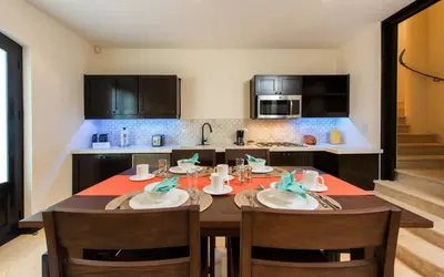 a kitchen with a wooden table with chairs and a kitchen with at Calle La Ronda 15 At Las Catalinas in Playa Danta