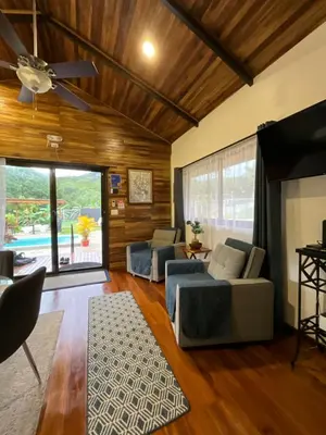 a living room with couches and a flat screen tv at Casa Cooper in Carrillo
