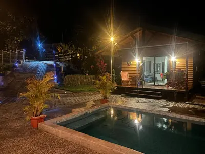 a swimming pool in front of a house at night at Casa Cooper in Carrillo