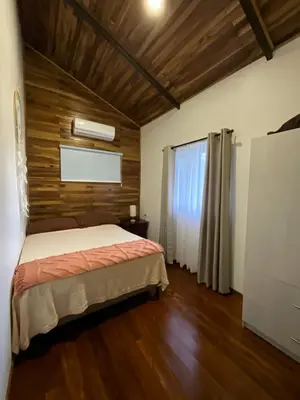 a bedroom with a bed and a wooden wall at Casa Cooper in Carrillo