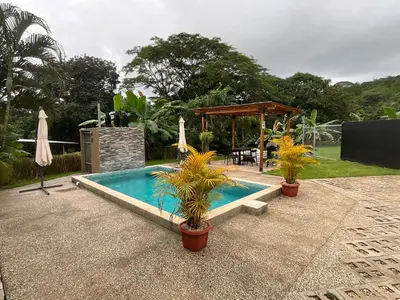 a swimming pool with potted plants and a gazebo at Casa Cooper in Carrillo