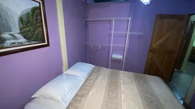 a small purple room with a bed and a door at Casa Rural Aralia in Fortuna