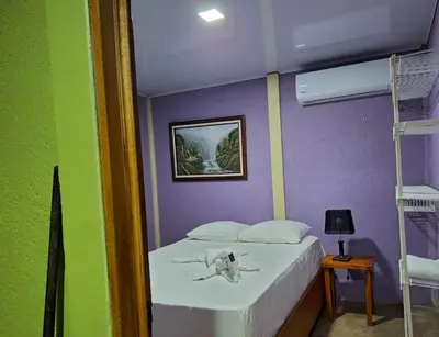 a bedroom with a white bed with a purple wall at Casa Rural Aralia in Fortuna