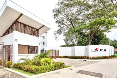 a white building with a sign on it at Bright & Airy new Condo, 5 min walk to Jaco Beach! in Jacó