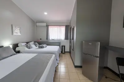 a hotel room with two beds and a refrigerator at Villas Fortuna Boutique in Fortuna