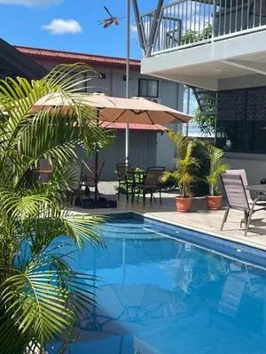 a pool with chairs and umbrellas next to a building at Villas Fortuna Boutique in Fortuna