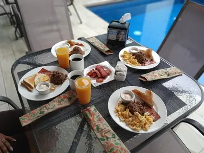 a table with plates of breakfast food and orange juice at Villas Fortuna Boutique in Fortuna