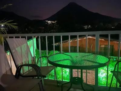 a glass table and chairs on a balcony at night at Villas Fortuna Boutique in Fortuna
