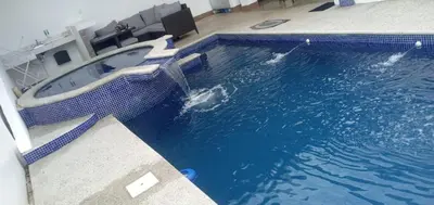 a swimming pool with a tub in the middle of it at Casa de playa Herradura con piscina y jacuzzi in Puntarenas