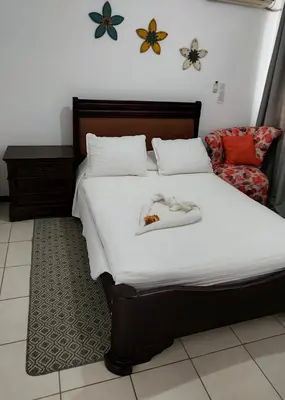 a bedroom with a bed with two shoes on it at Casa de playa Herradura con piscina y jacuzzi in Puntarenas