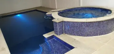 a large tub with blue tile in a bathroom at Casa de playa Herradura con piscina y jacuzzi in Puntarenas