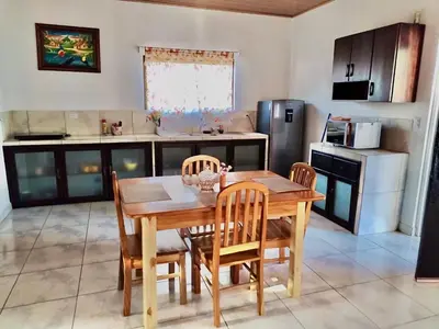 a kitchen with a wooden table and chairs in a kitchen at Casa Paraiso Parrita in Parrita