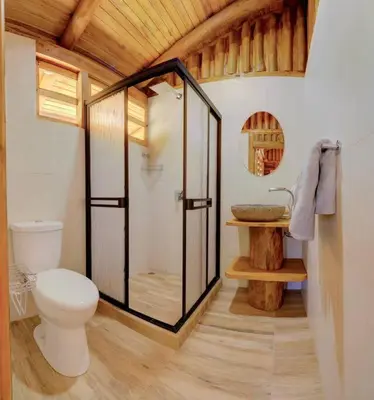 a bathroom with a toilet and a glass shower at Sámara Tarantela Houses, Casa Melina in Sámara