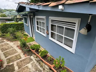 a blue house with two windows and some plants at Hermosa Cabaña en Cartago! Cabaña Providencia! in Cartago