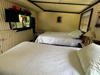 a bedroom with two beds and a flat screen tv at Hermosa Cabaña en Cartago! Cabaña Providencia! in Cartago