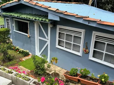 a blue house with two windows and some flowers at Hermosa Cabaña en Cartago! Cabaña Providencia! in Cartago