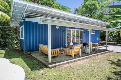 a blue tiny house with chairs and a table at Playa Potrero - Cute, modern Containerhome with pool for 2 people in Potrero