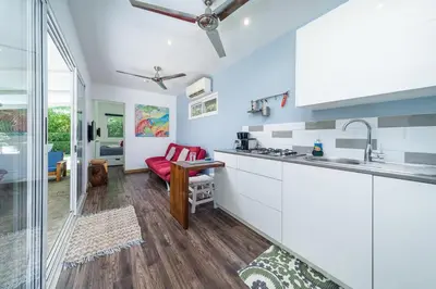 a kitchen with white cabinets and a red couch at Playa Potrero - Cute, modern Containerhome with pool for 2 people in Potrero
