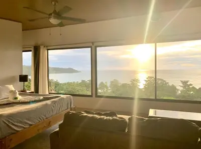 a bedroom with a bed and a large window at Nido Aracari in San Pedrillo