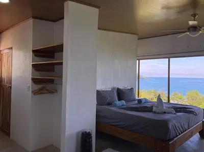 a bedroom with a bed with a view of the ocean at Nido Aracari in San Pedrillo