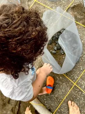 a young child is playing with a toilet on the floor at Nido Aracari in San Pedrillo