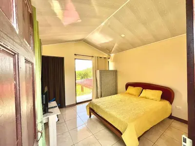 a bedroom with a bed with yellow sheets and a window at Apartment Buenos Aires, Puntarenas in Buenos Aires
