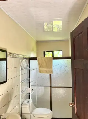 a bathroom with a toilet and a glass shower at Apartment Buenos Aires, Puntarenas in Buenos Aires