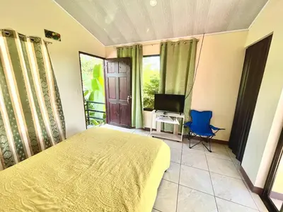 a bedroom with a bed and a tv and a chair at Apartment Buenos Aires, Puntarenas in Buenos Aires