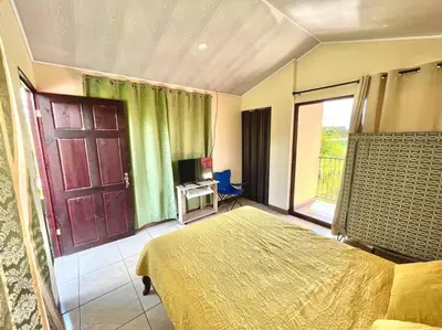a bedroom with a bed and a door and a window at Apartment Buenos Aires, Puntarenas in Buenos Aires
