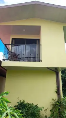 a yellow house with a balcony with at Apartment Buenos Aires, Puntarenas in Buenos Aires