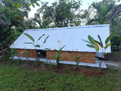 a house with a white roof and two plants at Chava Camping Rio Celeste in Rio Celeste