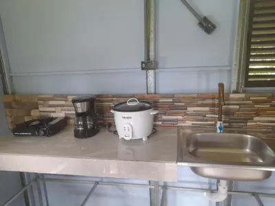 a slow cooker sitting on a counter next to a sink at Chava Camping Rio Celeste in Rio Celeste