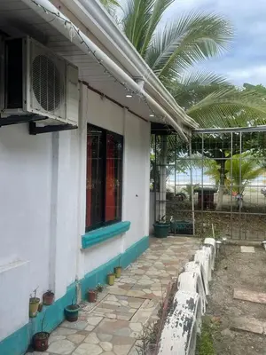 a row of white benches sitting outside of a building at Apartamentos Zamora in Puerto Limón