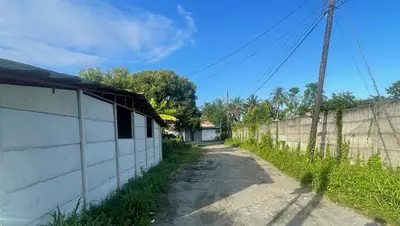 a dirt road next to a concrete wall at Apartamentos Zamora in Puerto Limón