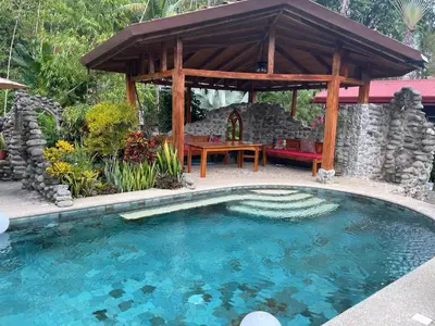 a swimming pool with a gazebo in a yard at Toucan Villa -riverfront With Pool & Near A Beach in Uvita