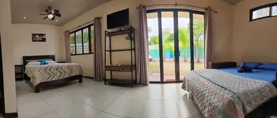 a bedroom with two beds and a sliding glass door at Casa Uvita Bay in Uvita