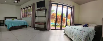 a bedroom with two beds and a large window at Casa Uvita Bay in Uvita