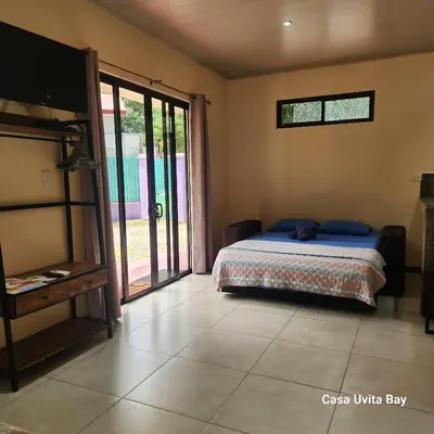 a bedroom with a bed and a sliding glass door at Casa Uvita Bay in Uvita