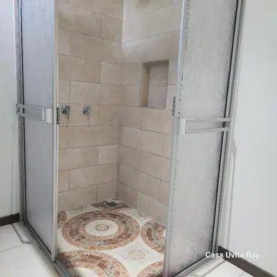 a shower with a glass door in a bathroom at Casa Uvita Bay in Uvita