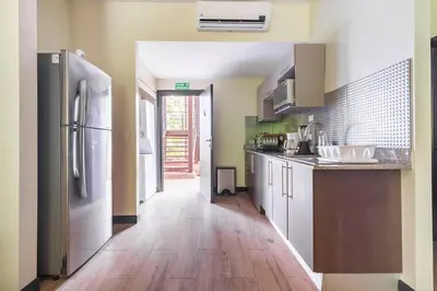 a kitchen with a refrigerator and a wooden floor at Condo Playa Hermosa, Puntarenas in Muñeco