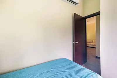 a bedroom with a bed and a door to a bedroom at Condo Playa Hermosa, Puntarenas in Muñeco